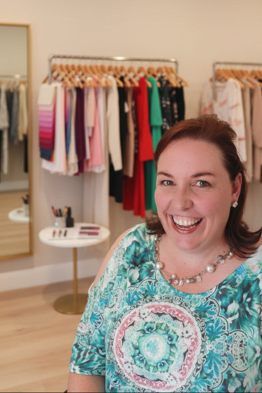 Jodi wearing a colourful patterned top in an indoor setting